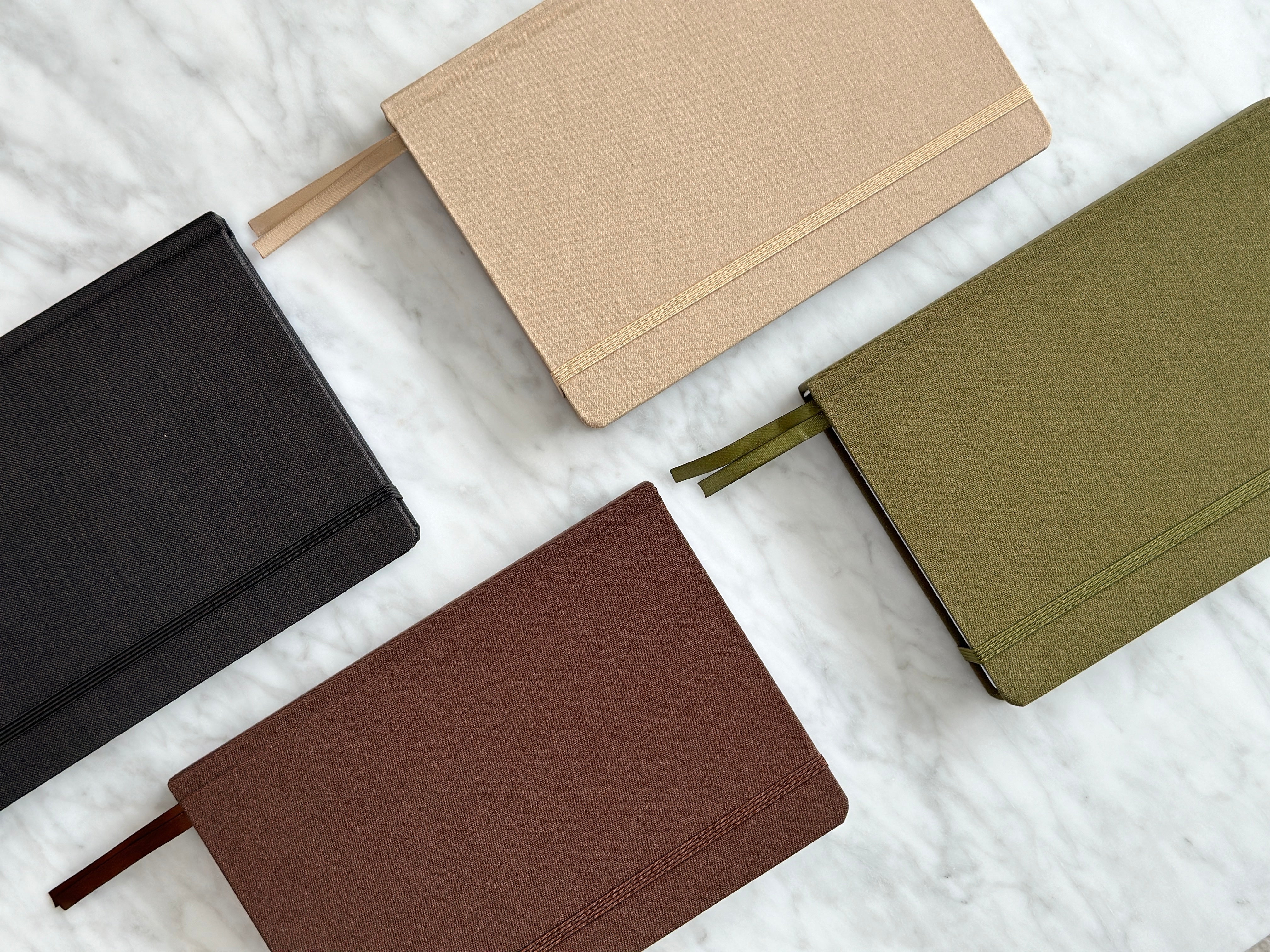 High quality linen hardcover bullet journals in black, brown, olive, and beige.