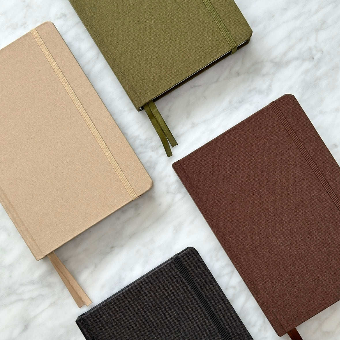 High quality linen hardcover bullet journals in black, brown, olive, and beige.